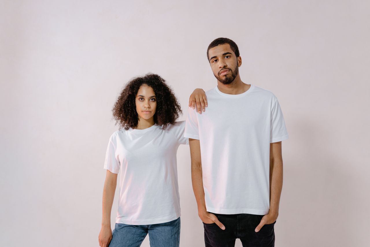 services-03 A young man and woman in casual white T-shirts, standing confidently for a fashion photoshoot.
